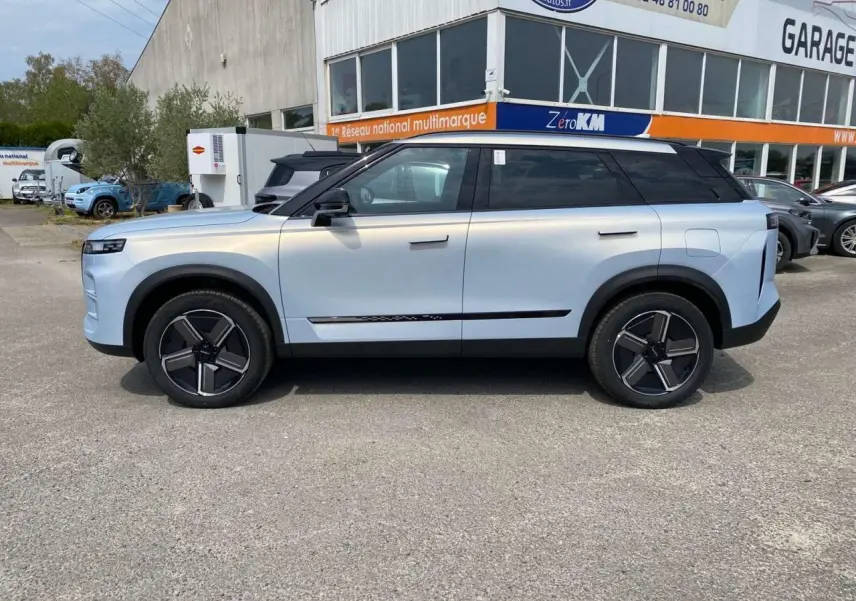 Vue de profil droit du SUV JAECOO J7 2026 en argent Moonlight, avec toit noir et jantes modernes bicolores.