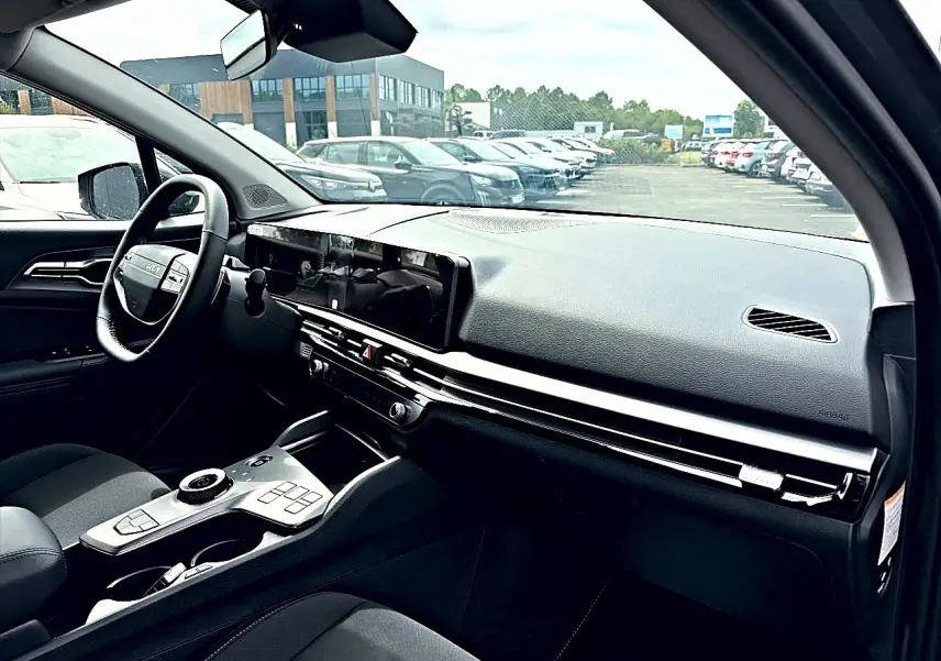 Vue intérieure côté conducteur du Kia Sportage 1.6 hybride gris eclipse, avec tableau de bord moderne et écran tactile large.
