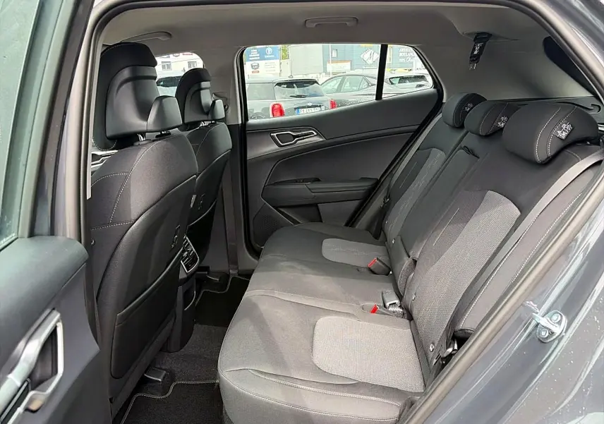 Vue intérieure côté droit montrant la banquette arrière grise eclipse du Kia Sportage 1.6 hybride 2026 avec appuie-têtes réglables.