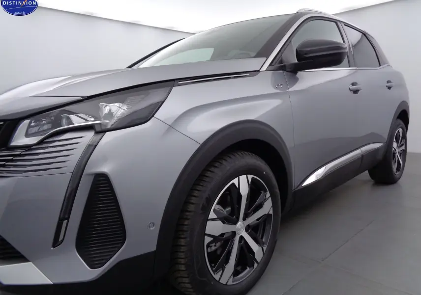 Vue 3/4 avant droit d'un Peugeot 3008 gris Artense métal avec jantes alliage et badge GT sur l'aile.