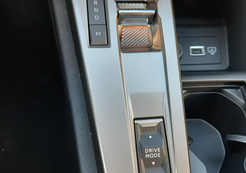 Gros plan sur la console centrale argentée de la Peugeot 308 Bleu Obsession, mettant en valeur la commande de boîte auto et le sélecteur Drive Mode.