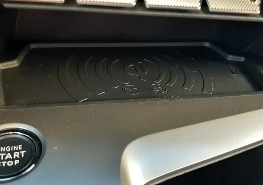 Détail de la console centrale du Peugeot 308 Bleu Obsession 2025 avec zone de charge sans fil et bouton start/stop.