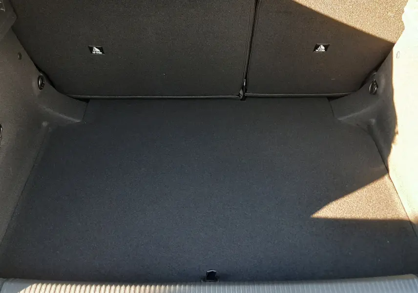 Coffre spacieux et propre de la Peugeot 308 Bleu Obsession vu de dessus, sans chargement visible.