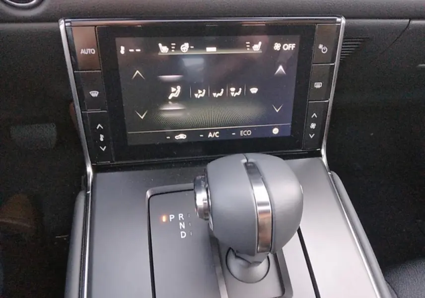 Gros plan sur la console centrale du Mazda MX-30 gris 2021, mettant en valeur le levier de vitesse automatique et l'écran tactile.
