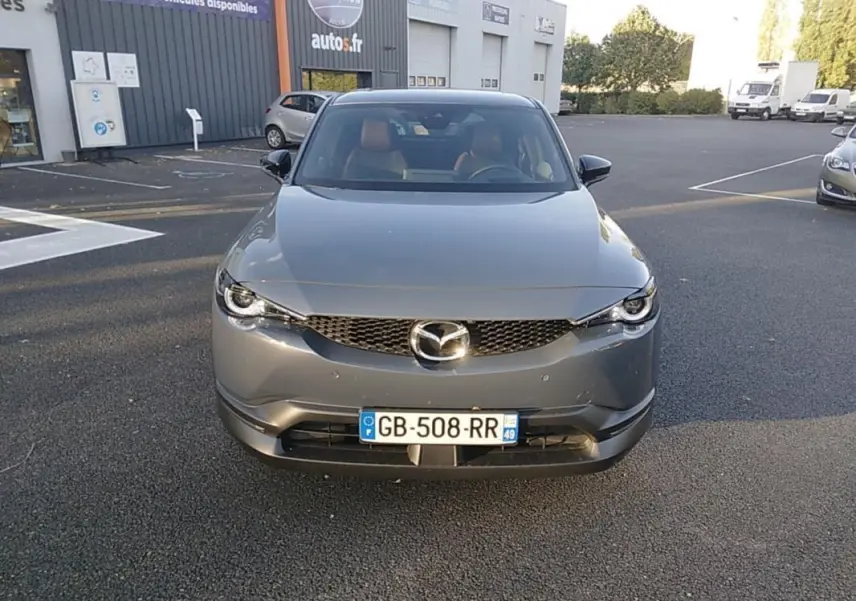 Vue frontale d'un Mazda MX-30 gris électrique 2021 avec calandre noire et plaques d'immatriculation françaises visibles.