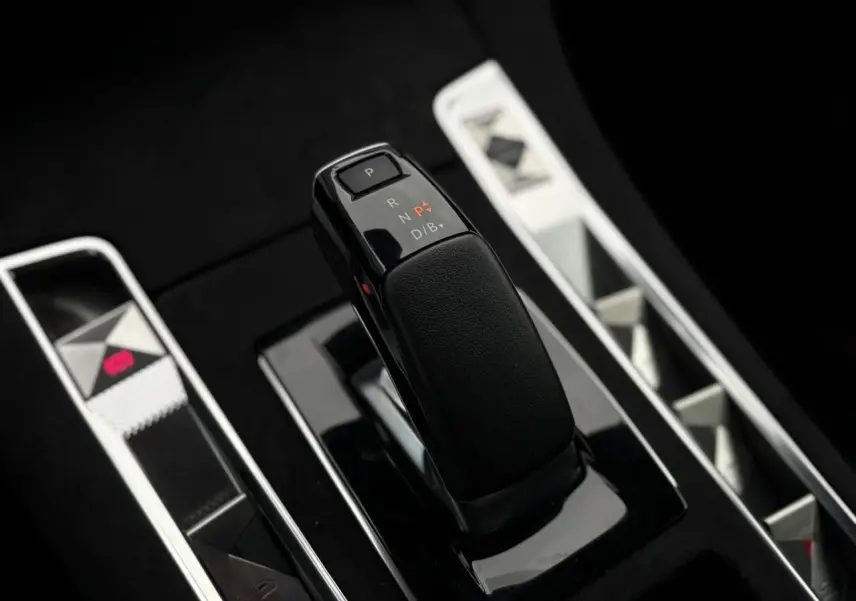 Le levier de vitesses noir brillant de la DS7 1.6 E-Tense 225 BVA vu en gros plan sur la console centrale.