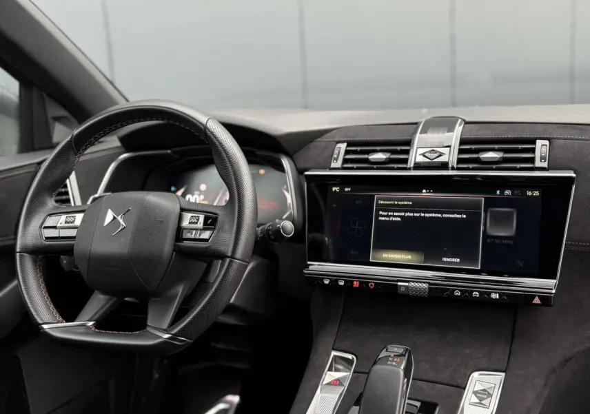 Vue intérieure du tableau de bord et volant DS7 1.6 E-Tense 2024 en Alcantara noir avec écran tactile large et finitions argentées.