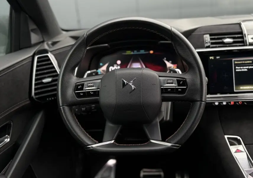 Volant en cuir noir perforé avec coutures or et carmin du DS7 1.6 E-Tense 2024, vue frontale intérieure centrée.