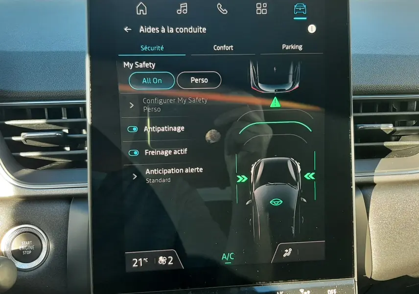 Écran tactile central du tableau de bord du Renault Captur bleu Iron 2025, affichant les aides à la conduite.