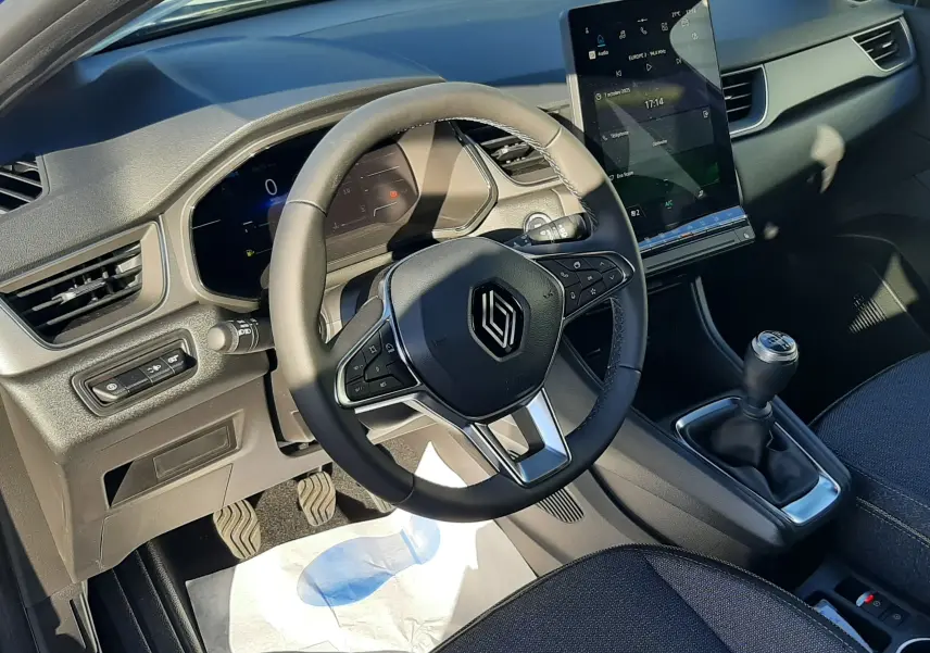 Intérieur du Renault Captur II Ph.2, vue côté conducteur sur le volant multifonction, tableau de bord numérique et levier de vitesses manuel.