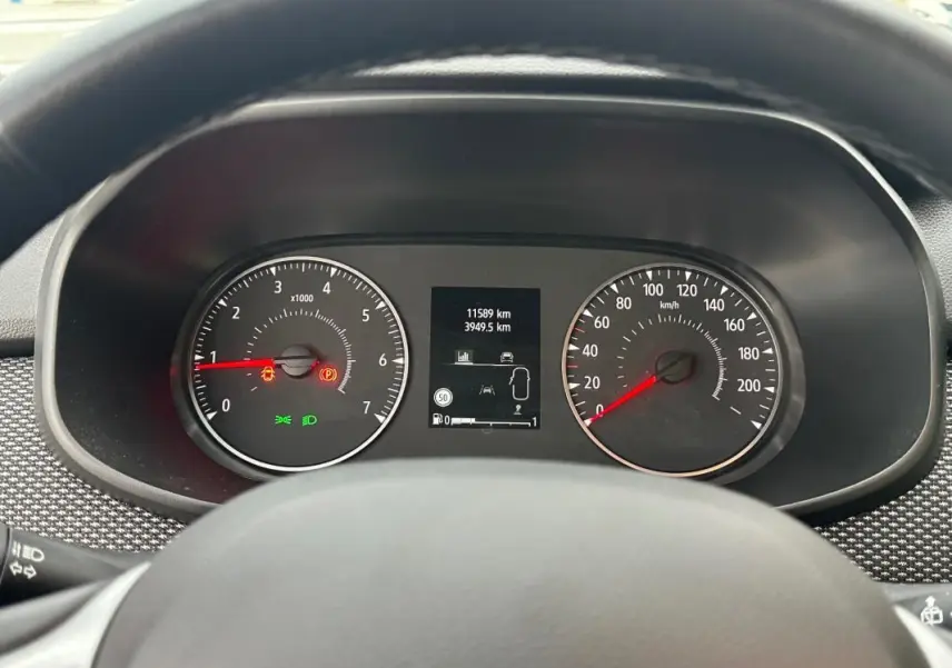 Vue rapprochée du tableau de bord de la Dacia Sandero blanche 2024, affichant compte-tours, vitesse et écran central.