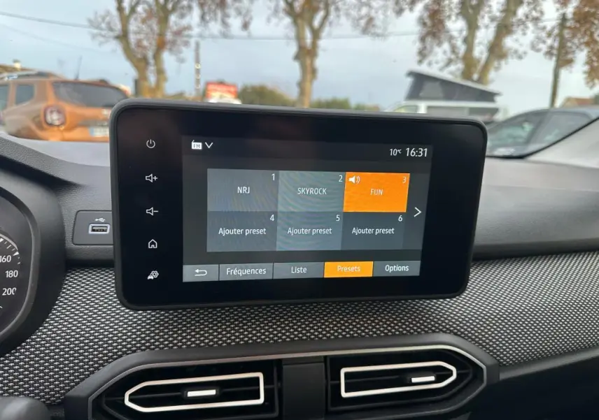 Écran tactile central de la Dacia Sandero TCe 90 2024, affichant les presets radio, intérieur noir.