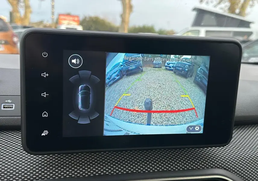 Écran intérieur de la Dacia Sandero blanc 2024 montrant la caméra de recul avec guidage coloré et capteur de stationnement.