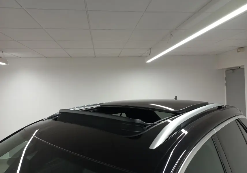 Toit ouvrant panoramique ouvert sur le dessus d’un Volkswagen T-Roc noir intense vu de trois quarts avant droit.