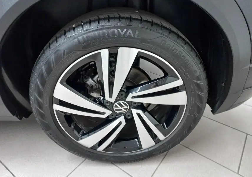 Gros plan sur la jante alliage bicolore noir et argent du Volkswagen T-Roc 1.5 TSI 150 DSG7 R-Line Noir Intense.