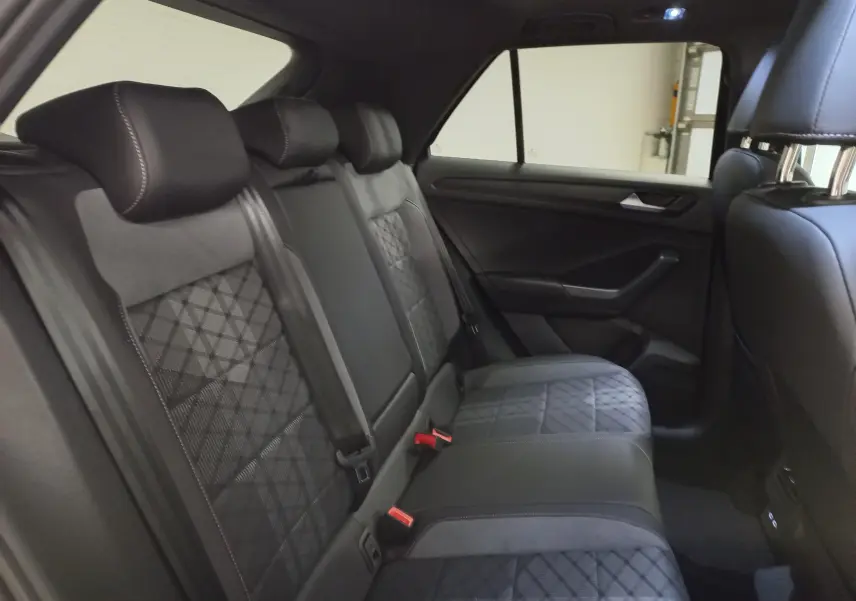 Vue intérieure côté droit des sièges arrière en cuir noir avec surpiqûres et motifs géométriques du Volkswagen T-Roc 2025.