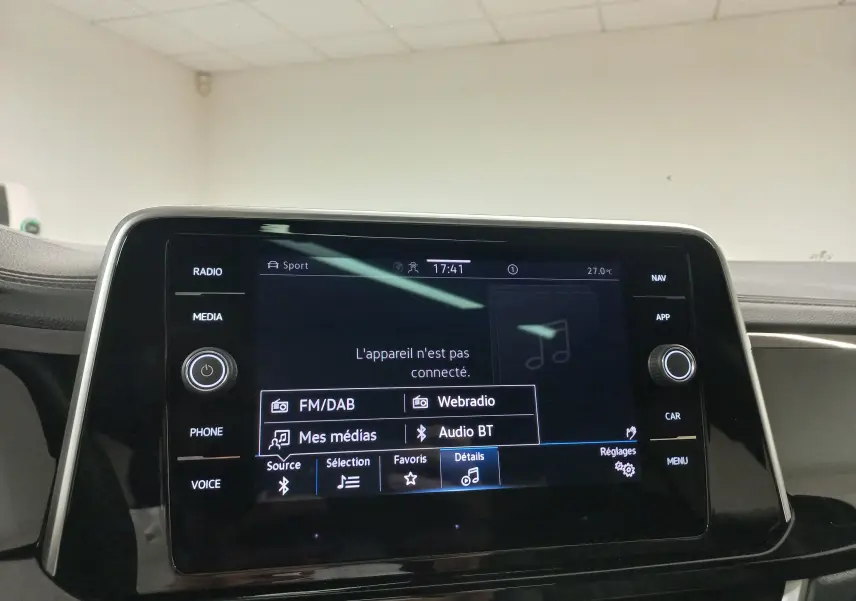 Vue intérieure centrée sur l’écran tactile multimédia du Volkswagen T-Roc 2025 avec interface radio et médias affichée.