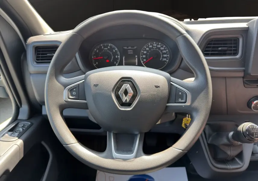 Vue intérieure centrée sur le volant noir du Renault Master 2024 avec tableau de bord et levier de vitesse manuel visible.