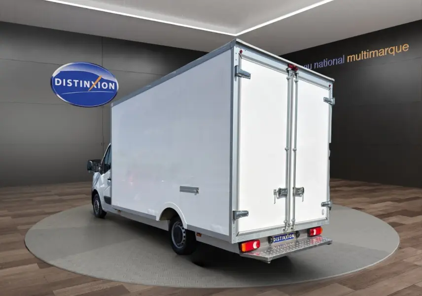 Vue 3/4 arrière d’un Renault Master blanc avec caisse fermée, portes arrière doubles et marchepied métallique.