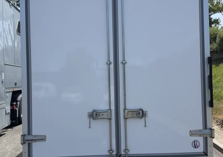 Vue arrière d’un utilitaire Renault Master blanc avec caisse fermée et double portes verrouillées, immatriculé DISTINXION.