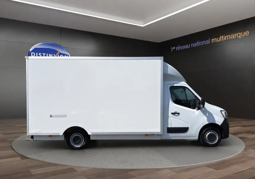 Renault Master blanc en vue profil droit, fourgon utilitaire avec caisse fermée volumineuse, présenté en showroom.