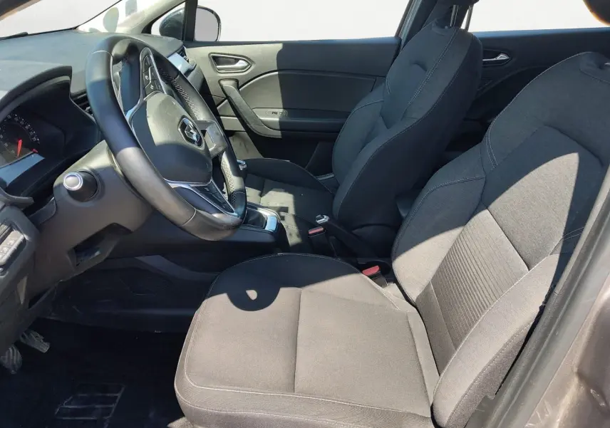 Vue intérieure côté conducteur du Renault Captur gris Cassiopée 2021, montrant sièges tissu et volant multifonction.