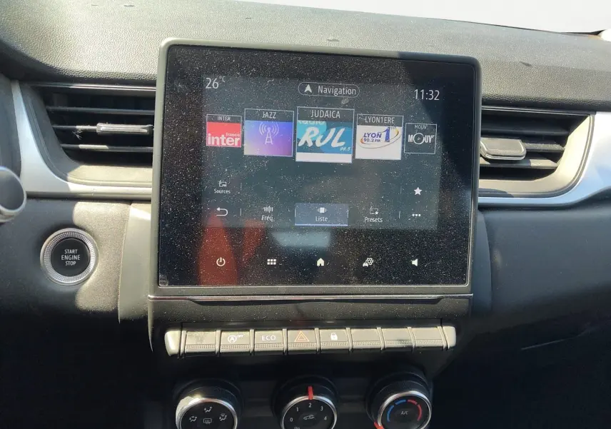 Vue rapprochée du tableau de bord du Renault Captur gris cassiopée 2021, avec écran tactile et commandes climatisation.