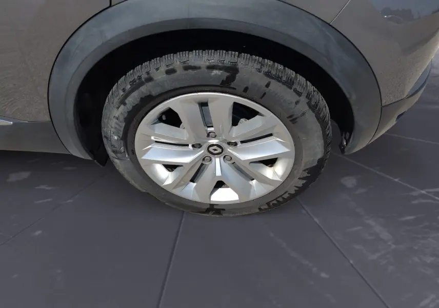 Gros plan sur la roue avant droite d’un Renault Captur gris Cassiopée, mettant en valeur la jante alliage et le pneu.
