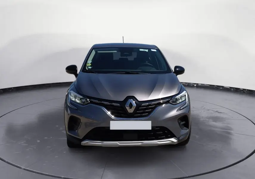 Vue de face du Renault Captur 1.5 Blue dCi 115 Business gris Cassiopée avec calandre chromée et phares LED allumés.