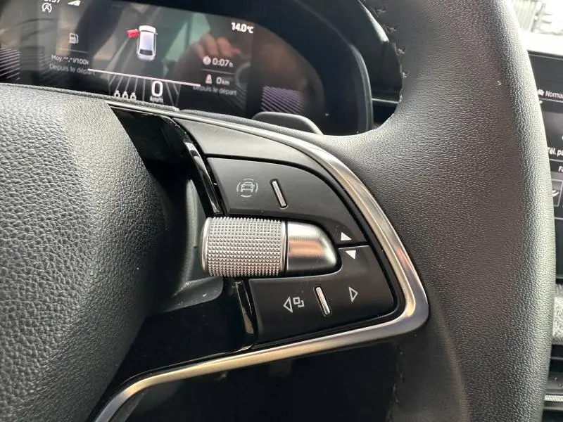 Gros plan sur les commandes multifonctions à droite du volant cuir noir d'une Skoda Scala 2025, intérieur moderne.