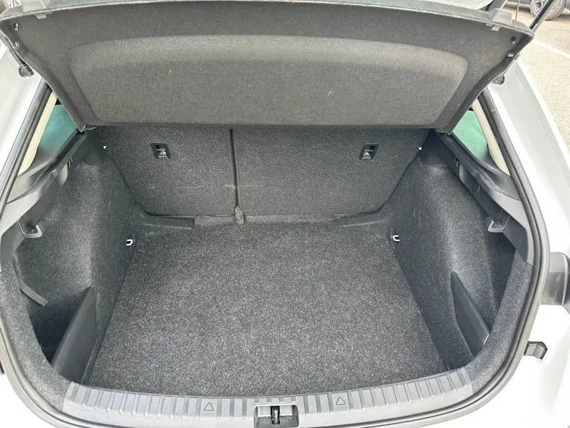 Coffre ouvert vu de l'arrière d'une Skoda Scala blanc cristal, montrant un espace de chargement propre et spacieux.