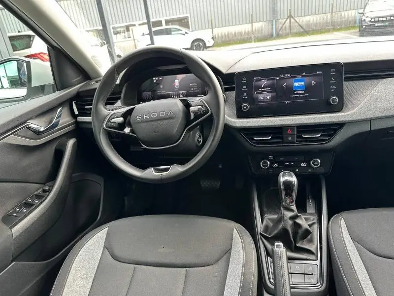 Vue intérieure de face du poste de conduite de la Skoda Scala blanc cristal, avec volant cuir multifonction et écran tactile central.