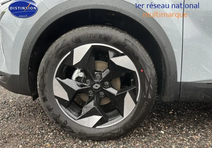 Gros plan sur la roue avant gauche du Renault Captur gris rafale avec jante alu bicolore au design géométrique.
