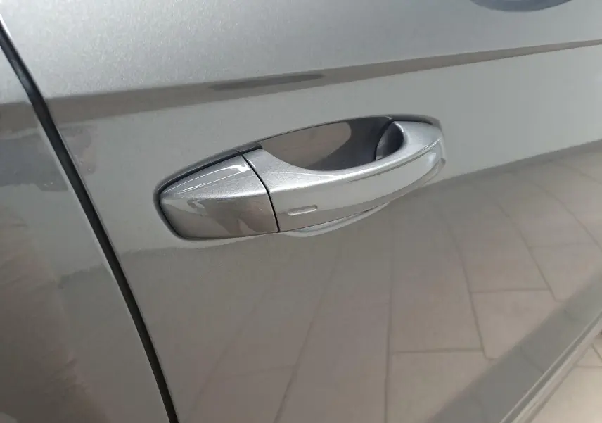 Poignée de porte côté gauche en gros plan sur Volkswagen T-Roc 2025 gris Indium métallisé.
