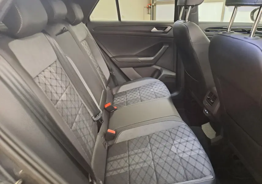 Vue intérieure côté droit des sièges arrière en tissu et cuir du Volkswagen T-Roc 2025 gris Indium avec toit noir.