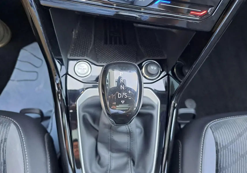 Vue rapprochée du levier de vitesses automatique noir brillant du Volkswagen T-Roc 1.5 TSI R-Line avec console centrale noire.