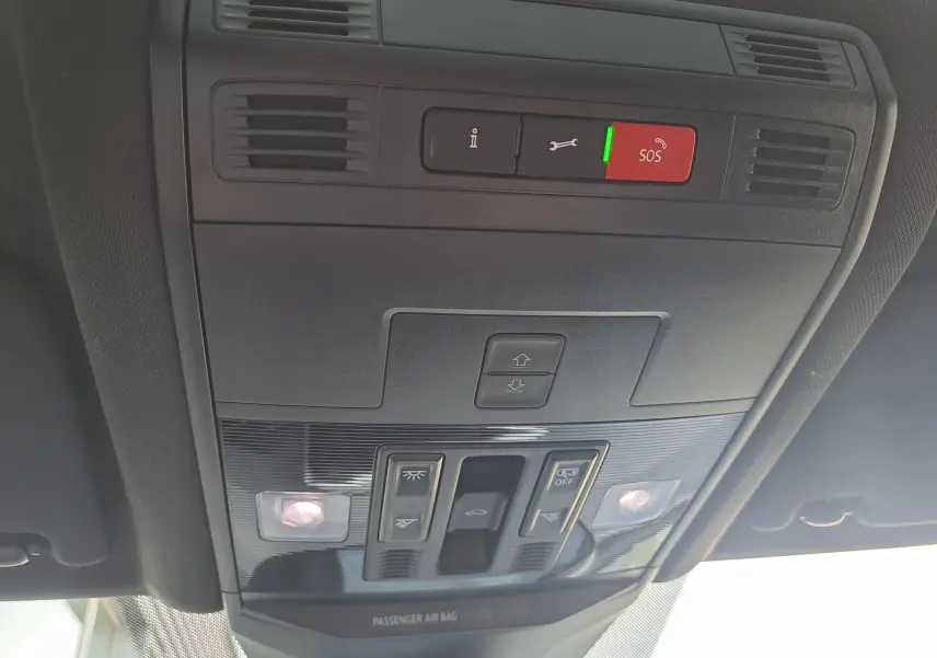 Vue en gros plan du panneau de commandes du toit ouvrant et des éclairages intérieurs du Volkswagen T-Roc 2025 gris Indium avec toit noir.