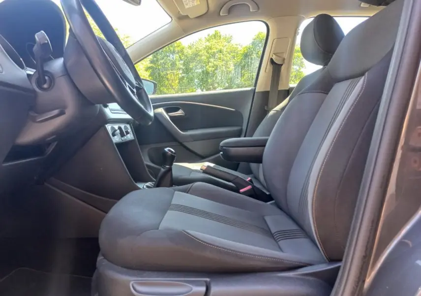 Intérieur avant droit de la Volkswagen Polo gris 2016, montrant les sièges tissu et la boîte manuelle.