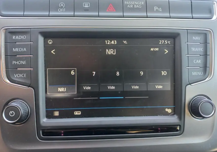 Tableau de bord de Volkswagen Polo gris 2016, vue rapprochée de l'écran multimédia affichant la radio NRJ.