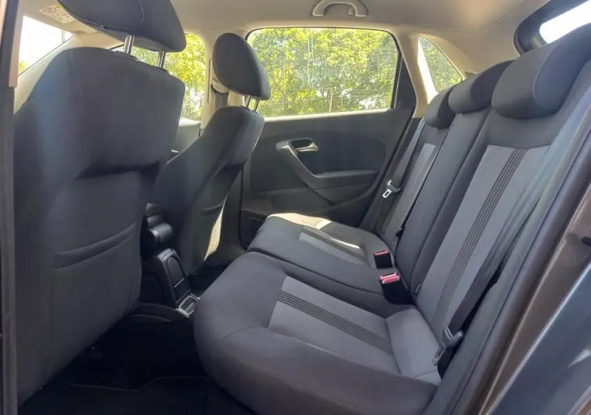 Vue intérieure côté droit des sièges arrière gris foncé de la Volkswagen Polo 2016 avec appuie-têtes et ceintures visibles.