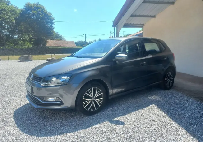 Volkswagen Polo gris 2016 vue 3/4 avant côté gauche, avec jantes alliage et rétroviseurs argentés.