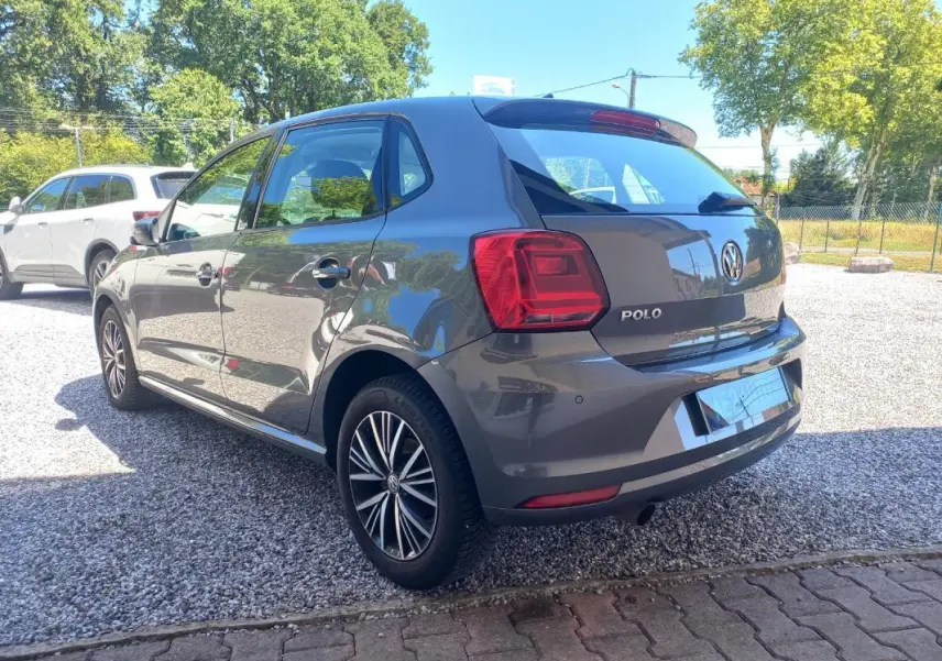 Vue 3/4 arrière droite d'une Volkswagen Polo gris métallisé 2016 avec jantes alliage et feux arrière distinctifs.