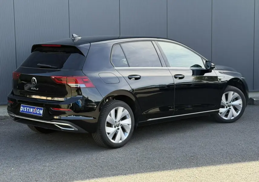 Volkswagen Golf VIII noire vue 3/4 arrière droit, avec jantes alliage 17 pouces et baguettes chromées.
