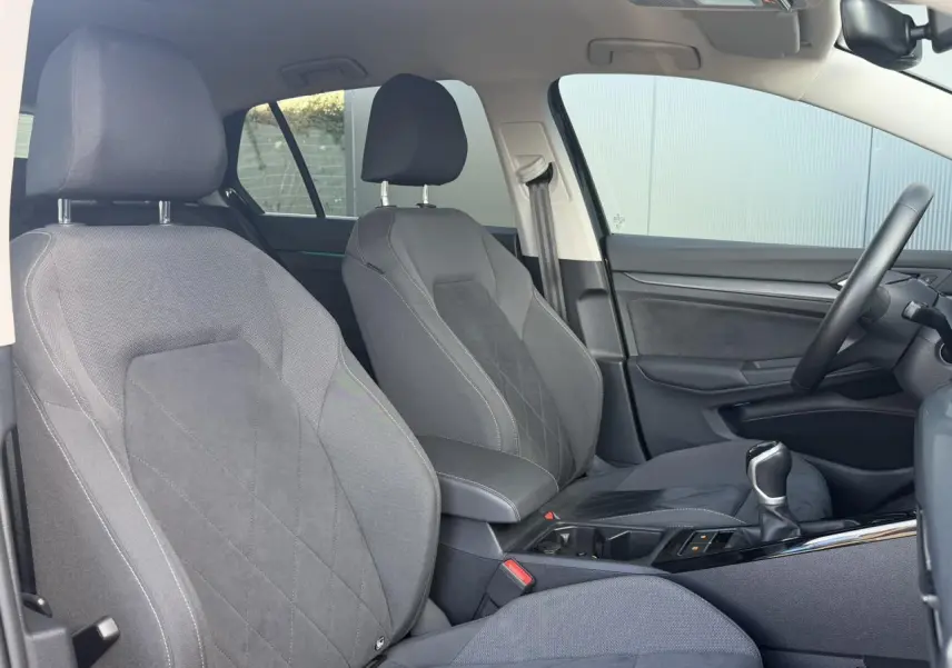 Vue intérieure côté droit de la Volkswagen Golf VIII 1.5 TSI 130 Style 2024, sièges microfleece gris et console centrale.
