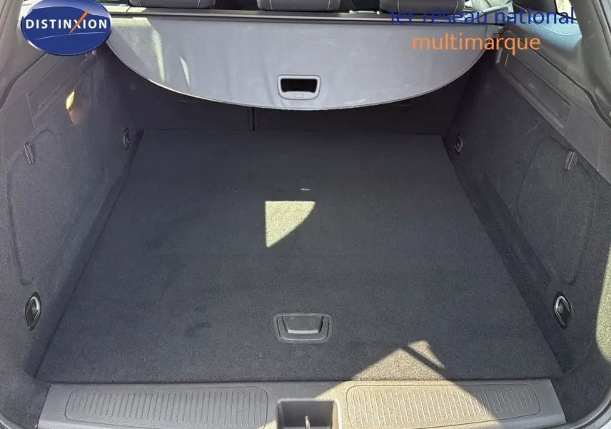 Coffre spacieux et propre de l’Opel Astra Sports Tourer gris minéral métal vu de l’arrière avec cache-bagages déployé.