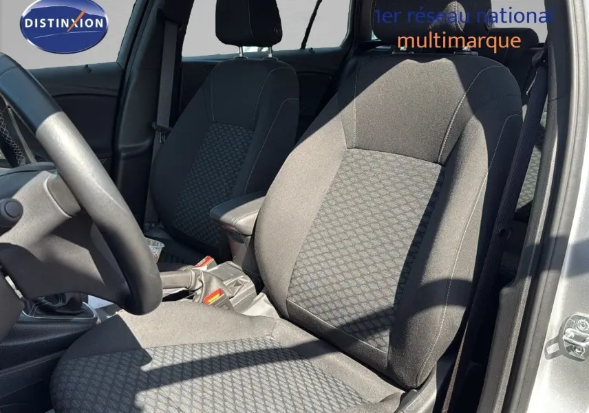 Vue intérieure côté conducteur de l'Opel Astra Sports Tourer gris minéral, mettant en valeur les sièges en tissu noir à motifs.