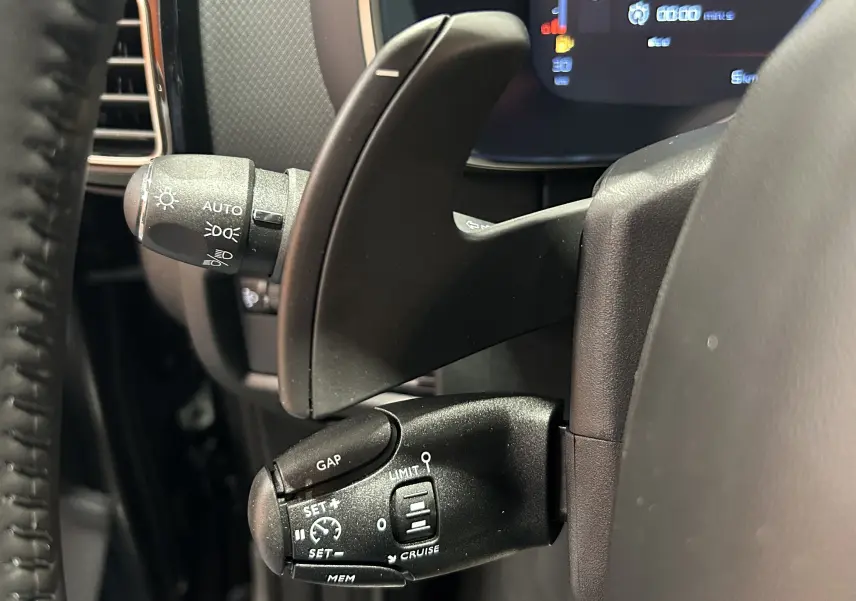 Gros plan sur la commande de régulateur de vitesse à gauche du volant du Citroën C5 Aircross gris platinium 2025.
