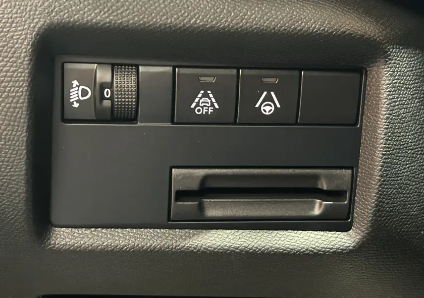 Panneau de commandes intérieures noires avec réglage des phares et boutons d'assistance au conducteur sur Citroën C5 Aircross.