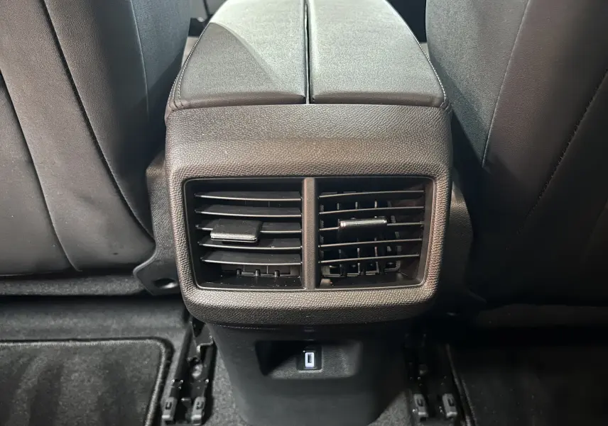 Gros plan sur la console arrière noire avec bouches d'aération et port USB du Citroën C5 Aircross 2025 gris platinium.