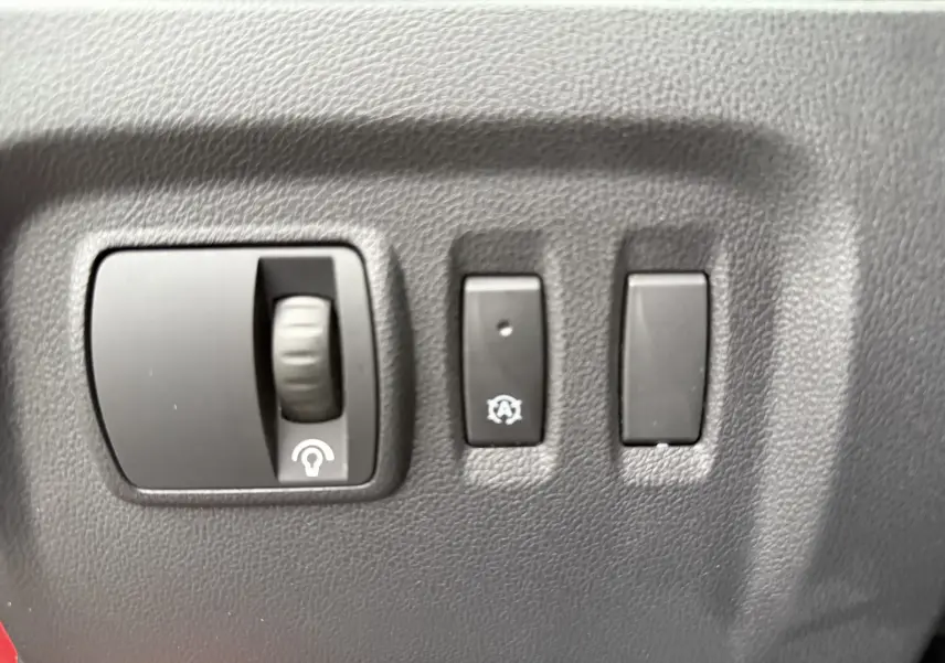 Gros plan sur les commandes de réglage de luminosité et arrêt automatique du moteur du Renault Captur rouge 2017.